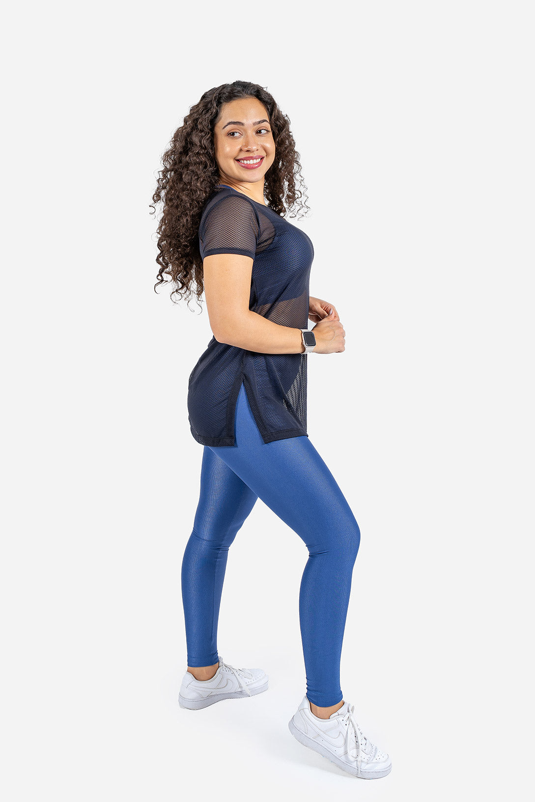 Woman wearing a black and blue athletic outfit on a white background