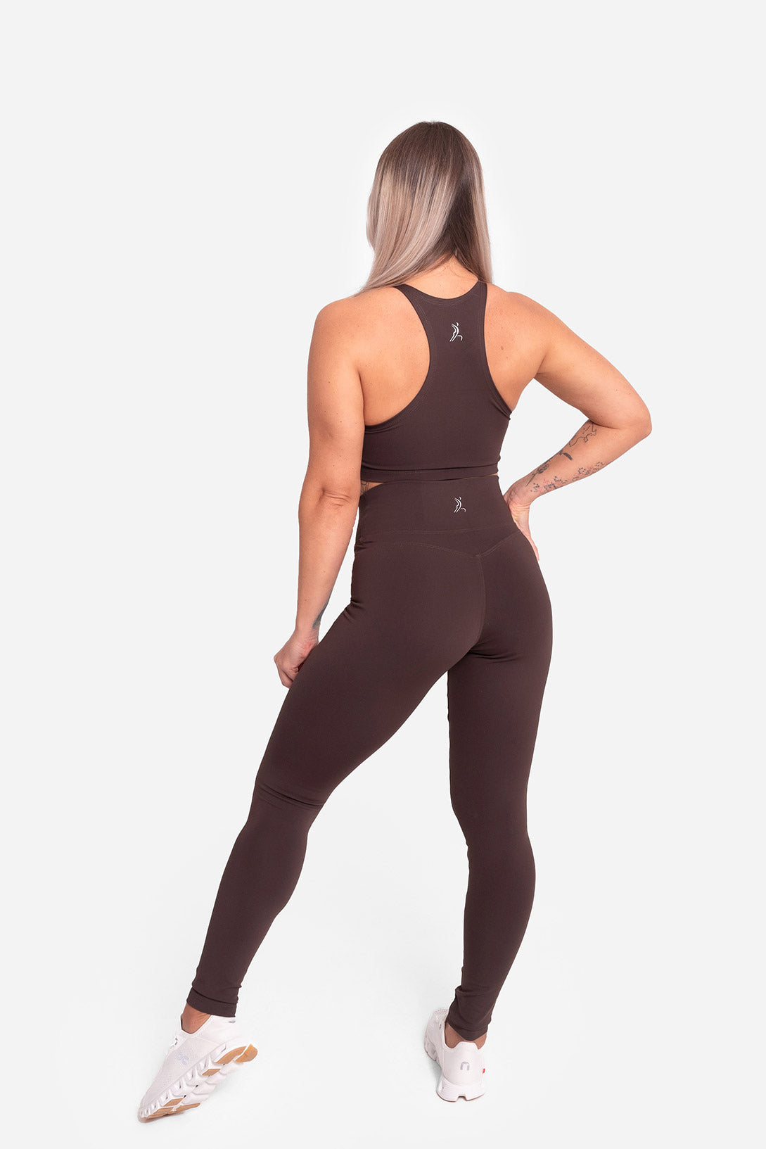 Woman wearing a brown athletic outfit on a white background