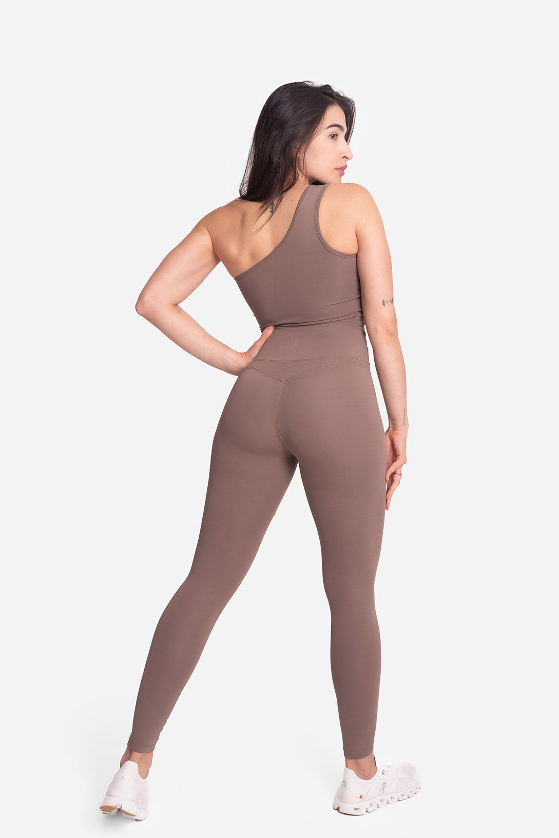 Woman wearing a brown jumpsuit on a white background