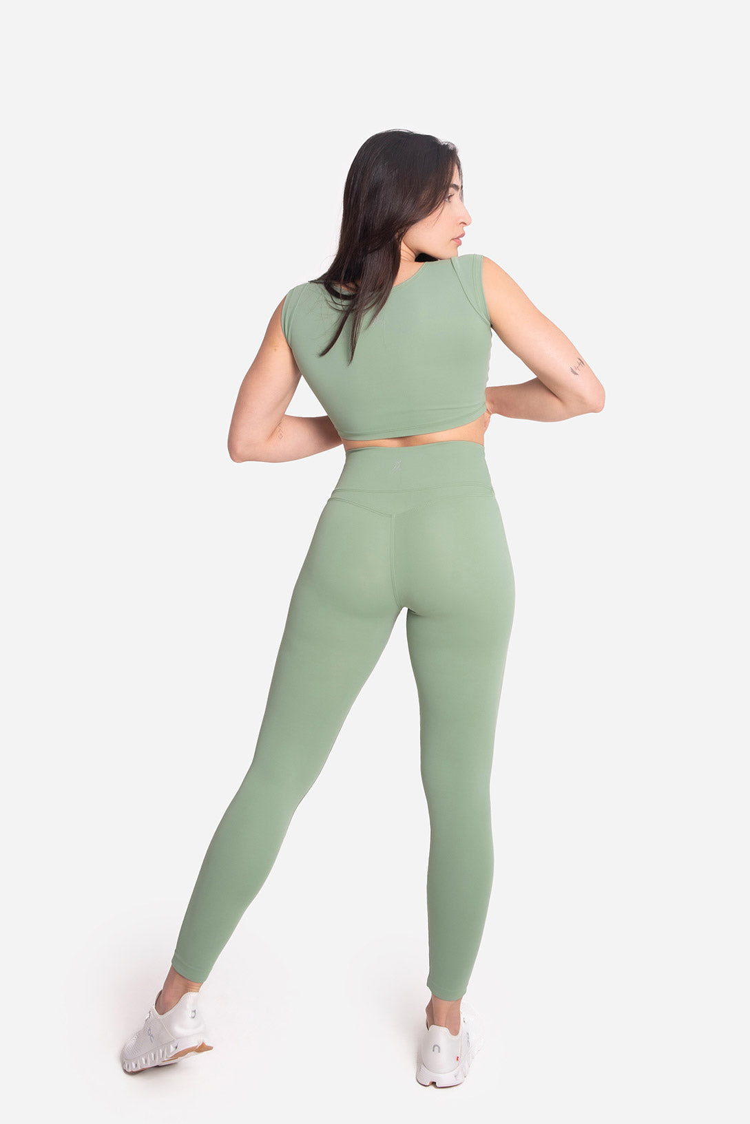 Woman wearing a green athletic outfit on a white background