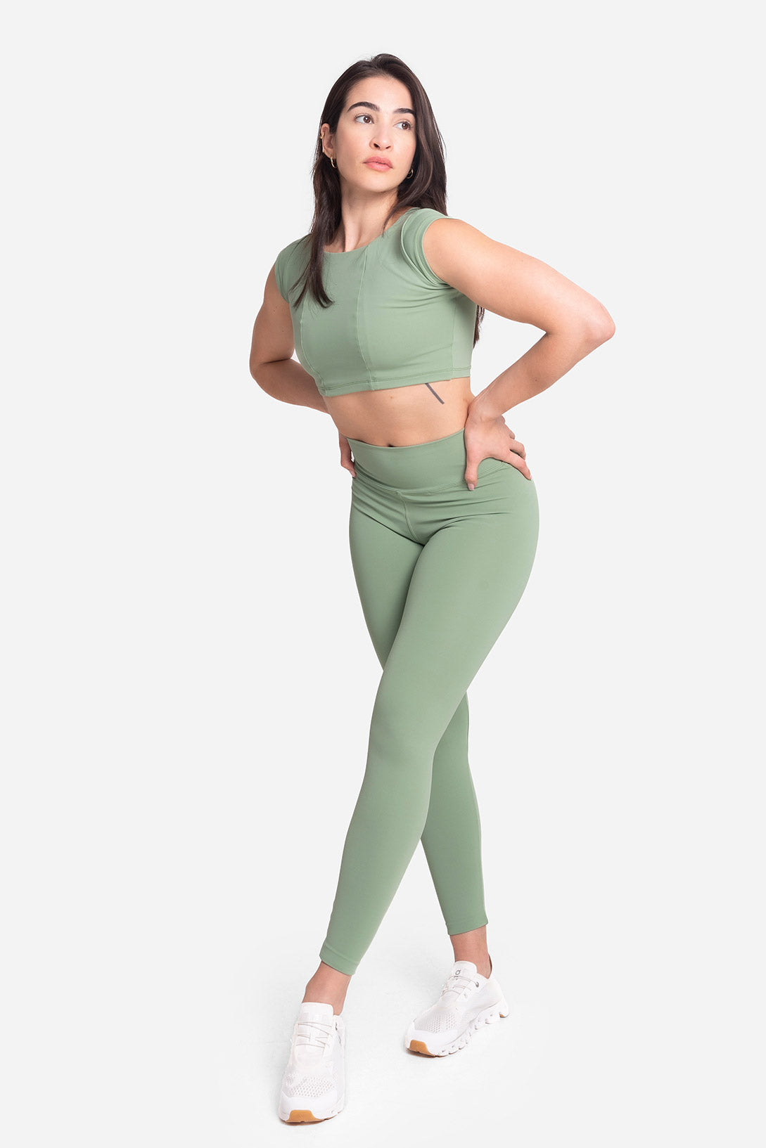Woman wearing a green athletic outfit on a white background