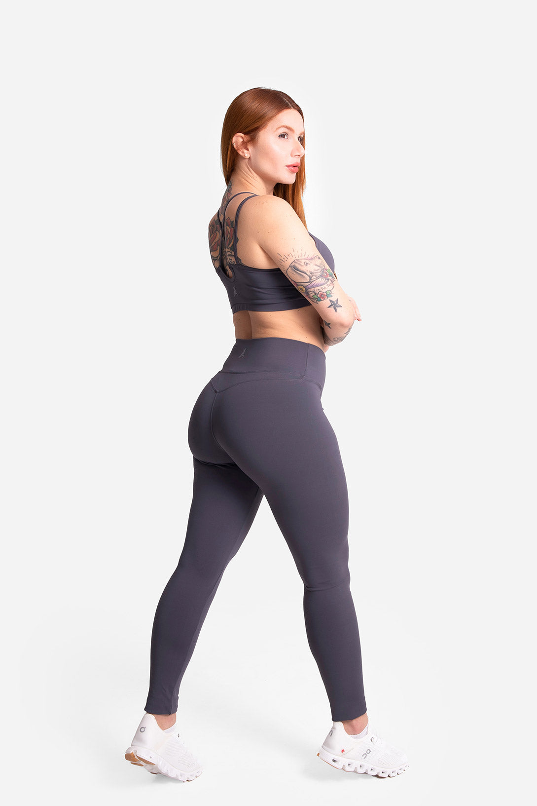 Woman wearing a gray athletic outfit on a white background