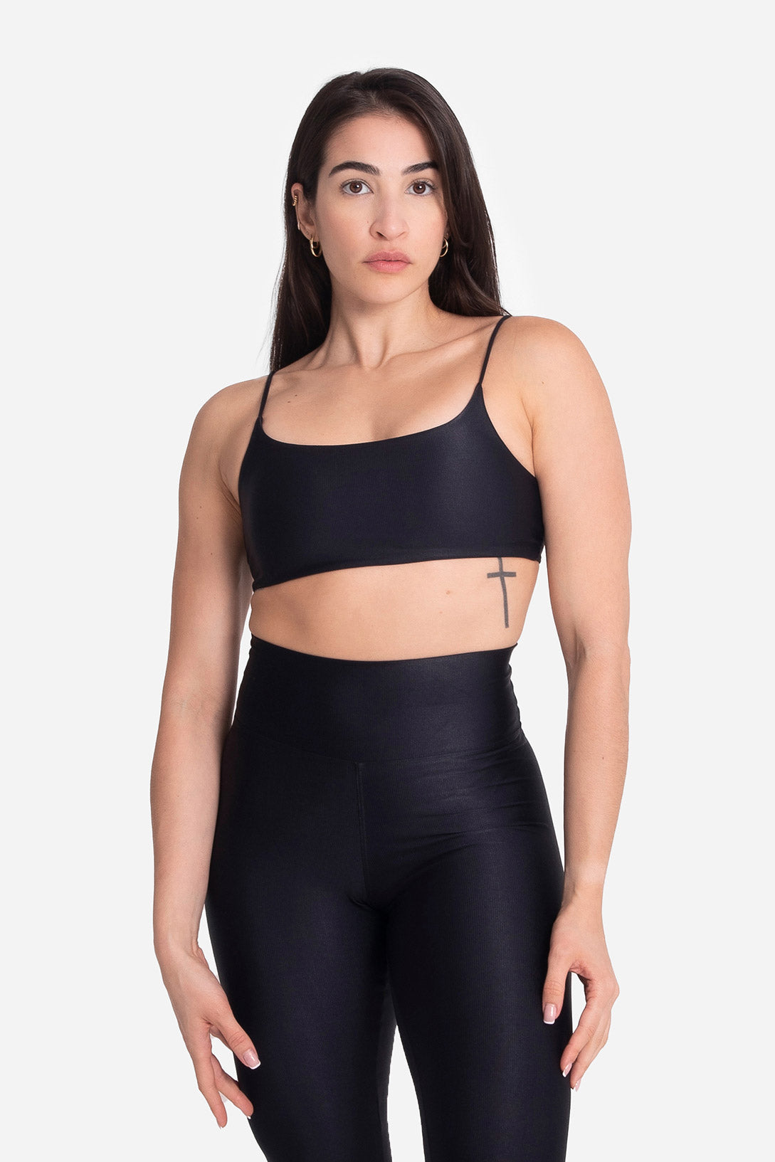 Woman wearing a black sports bra and leggings on a white background