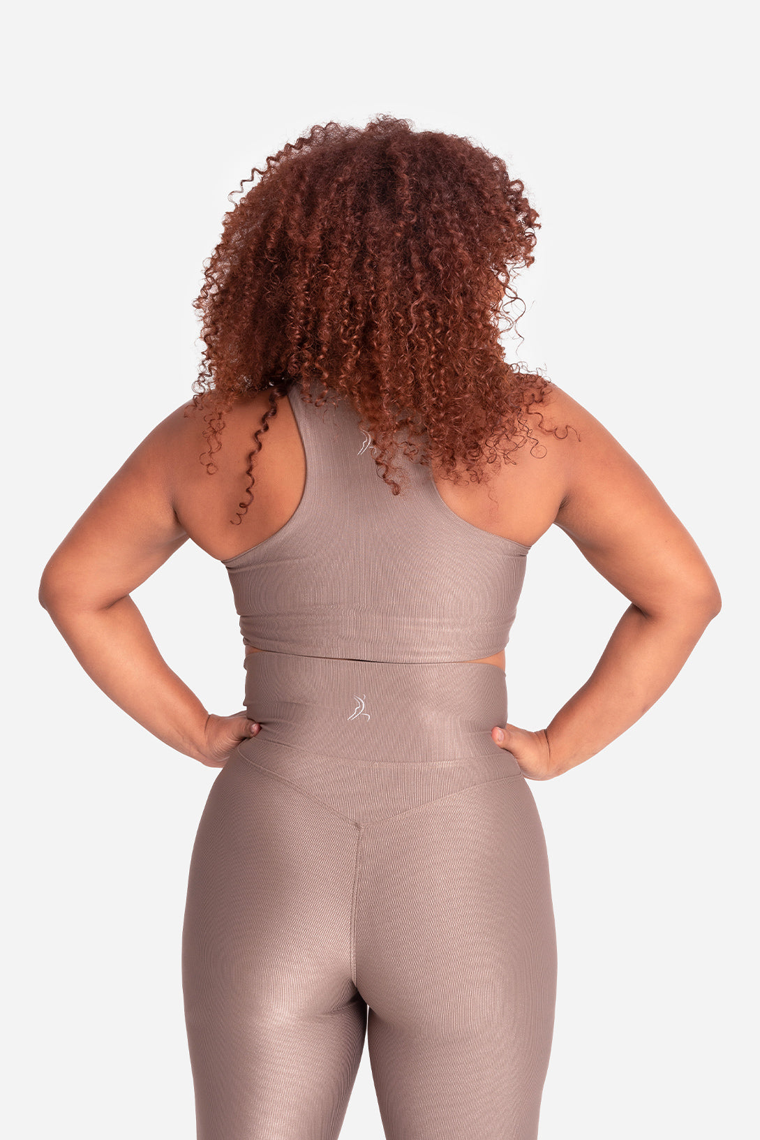 Person wearing a beige jumpsuit on a white background