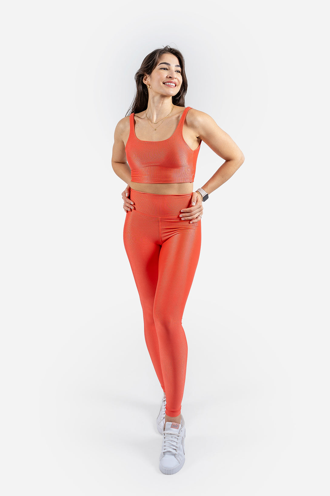 Woman wearing an orange athletic outfit on a white background