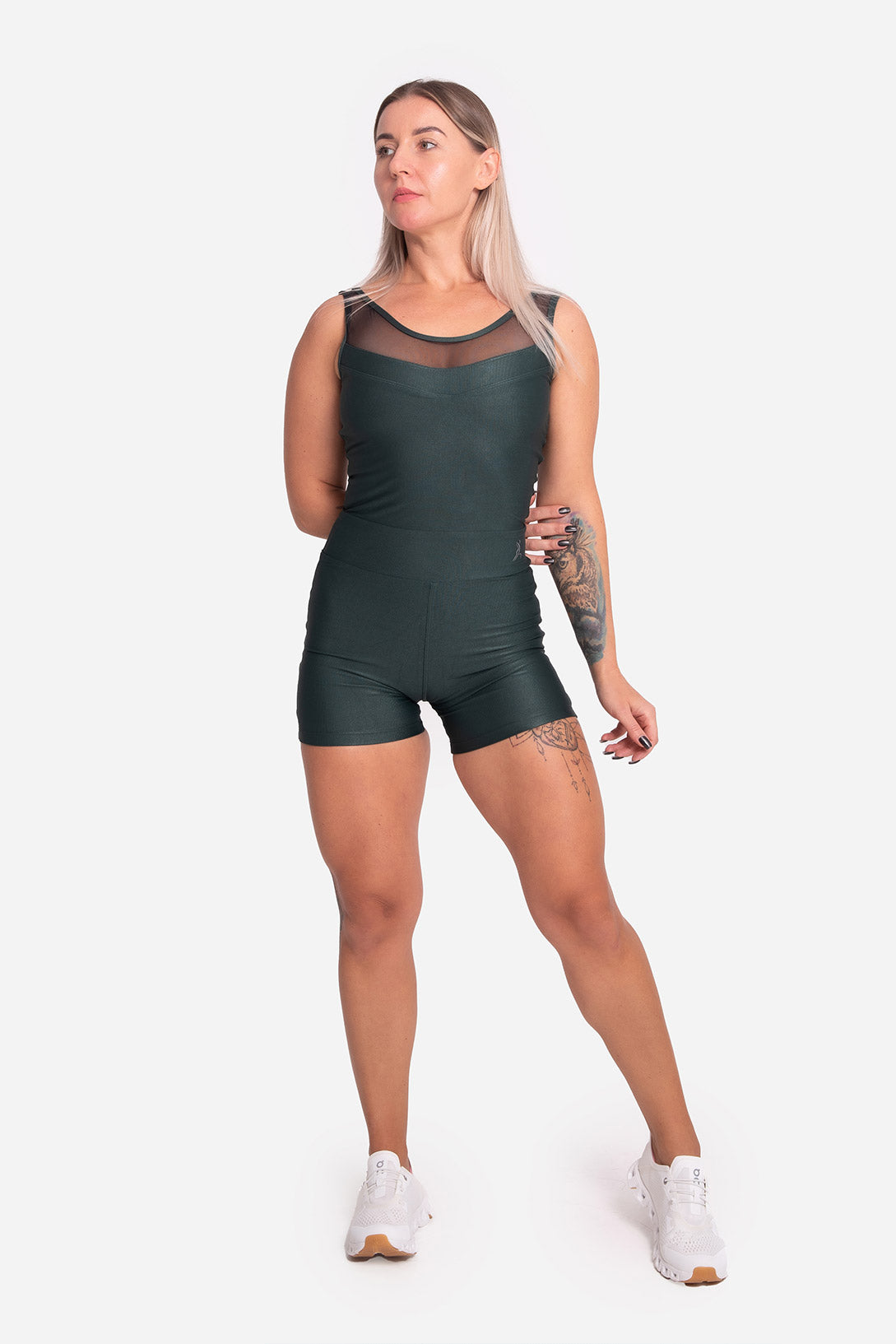 Woman wearing a green bodysuit on a white background