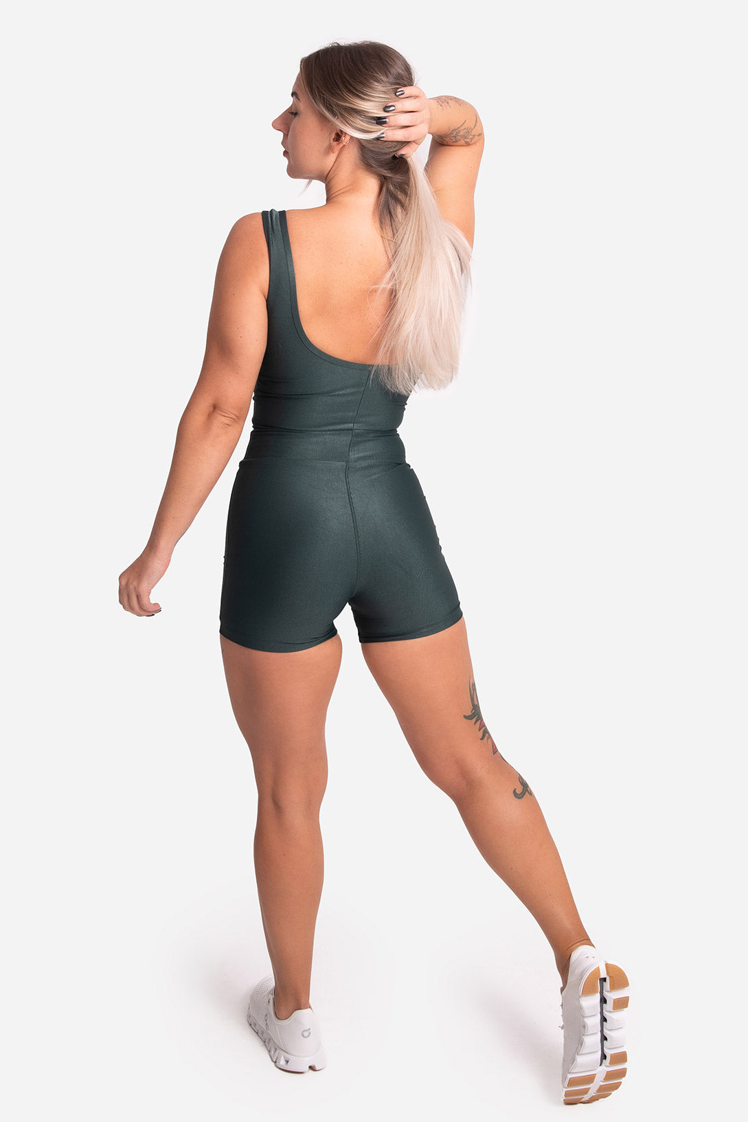 Woman wearing a green romper on a white background