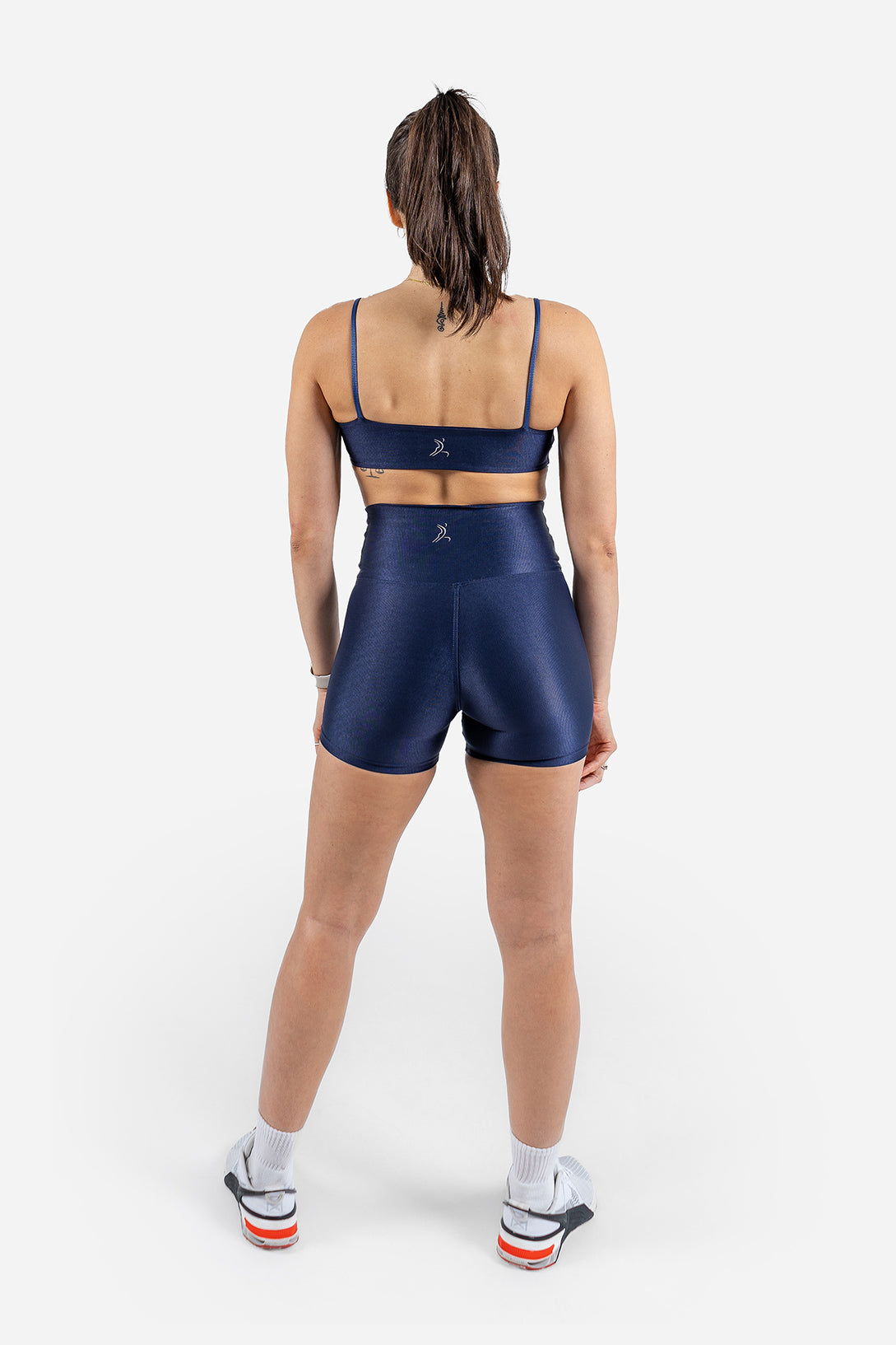 Person wearing a navy athletic outfit on a white background